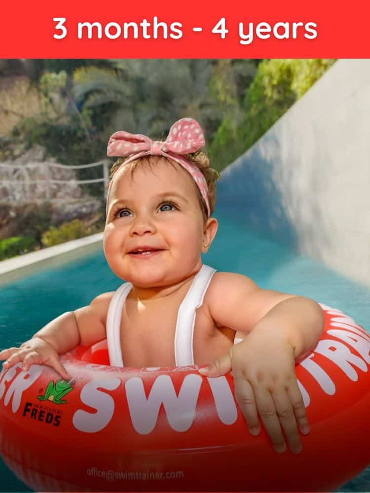 A baby floating happily in a red SWIMTRAINER Classic learn-to-swim ring