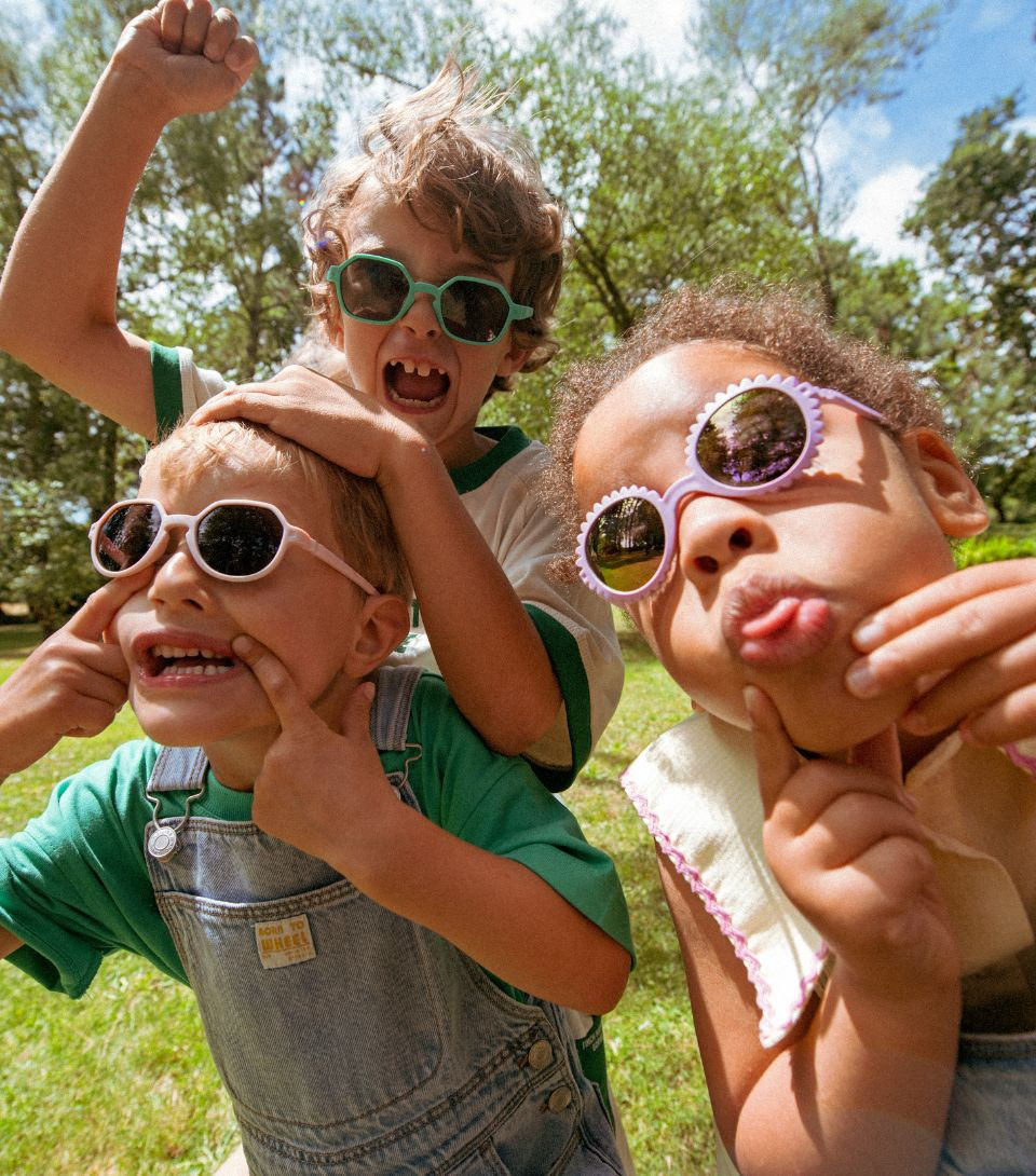 Young children in a garden wearing colourful Ki ET LA sunglasses