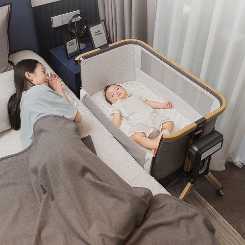 A parent beside their baby sleeping in a Lucky Baby bedside co-sleeper