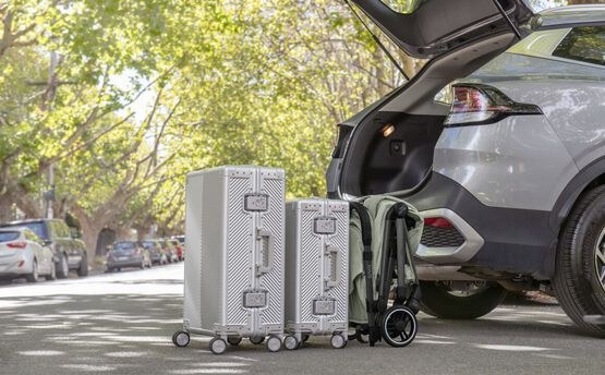 Britax Flylite folded to IATA cabin size beside cabin luggage at a car boot