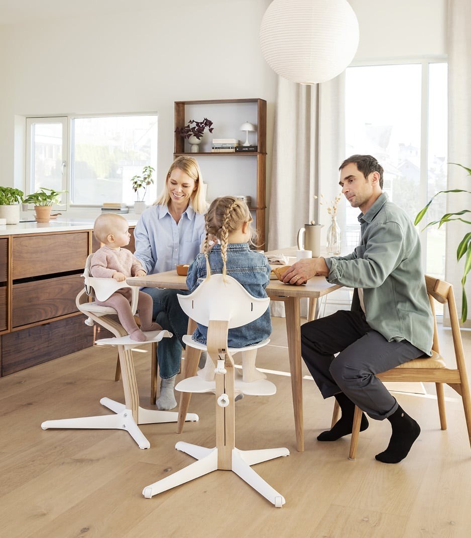 A family at the table with a child in a Nomi chair